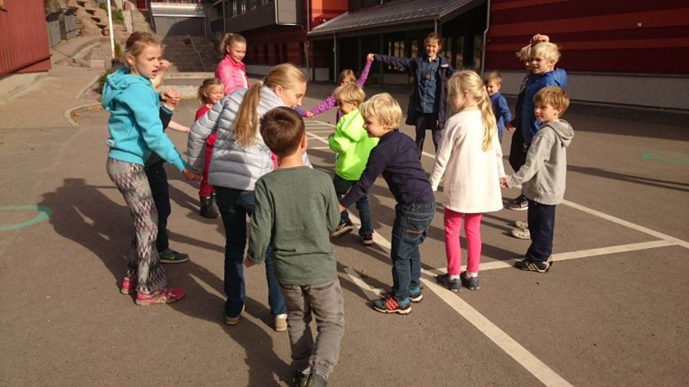 Fadderlek i skolegården med 1.trinn og 6.trinn.  Fadderne har ansvar for å organisere ulike ringleker.