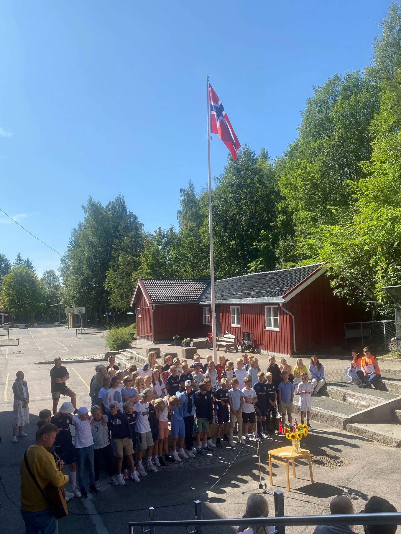 en gruppe mennesker som poserer for et bilde foran en flaggstang en gruppe mennesker som poserer for et bilde foran en flaggstang