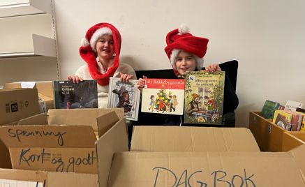 Et par barn i nisseluer som holder esker Et par barn i nisseluer som holder esker